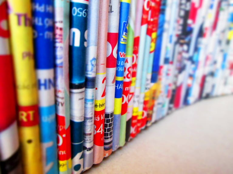 Close News Vibrant, assorted rolled magazines create a colorful display.