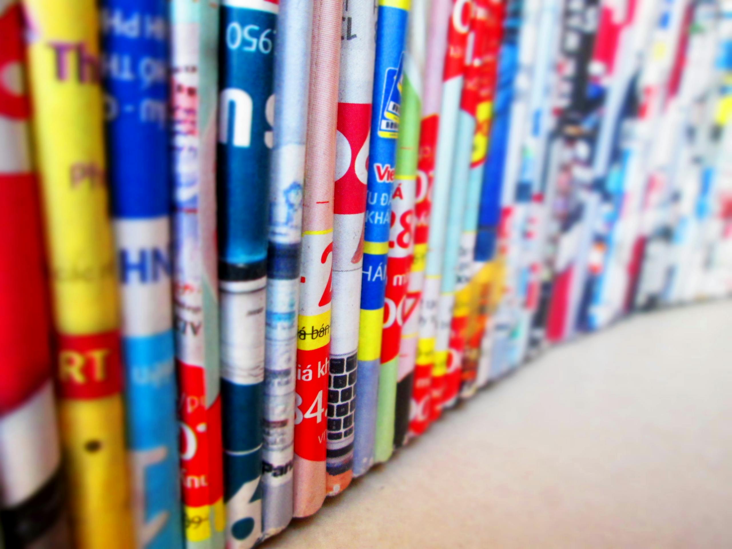 Close News Vibrant, assorted rolled magazines create a colorful display.
