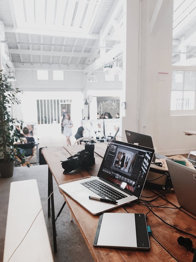 Global Digital Media Platform Launches to Redefine Independent NewsA bright, modern workspace featuring laptops, a camera, and a drawing tablet in an indoor office.