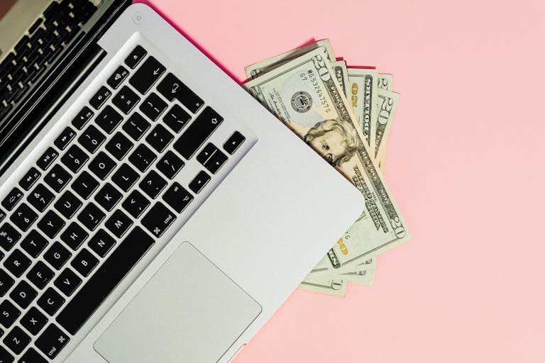 Freeoners: A Complete Guide to the Online Freelancing and Earning PlatformA laptop keyboard with dollar bills on a pink surface, symbolizing online business.