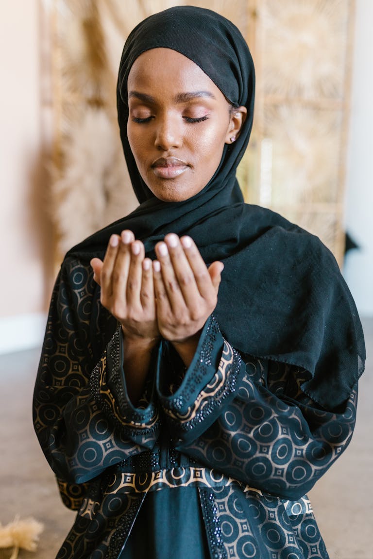 Hanuman Dham: A Sacred Abode of Faith, Strength, and Eternal Devotion 2026A woman in a hijab and traditional clothing prays with her eyes closed.