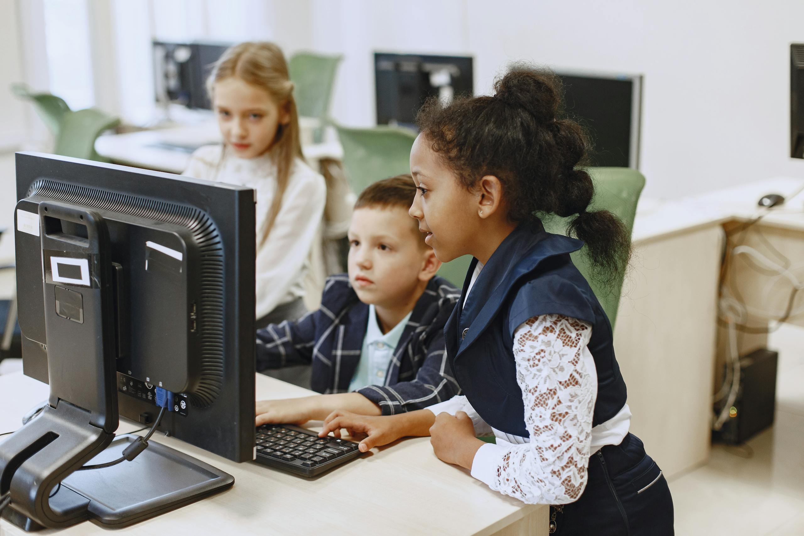 Nova Scola: Reimagining Education for the 21st CenturyDiverse group of children working together on computers in a modern classroom setting.
