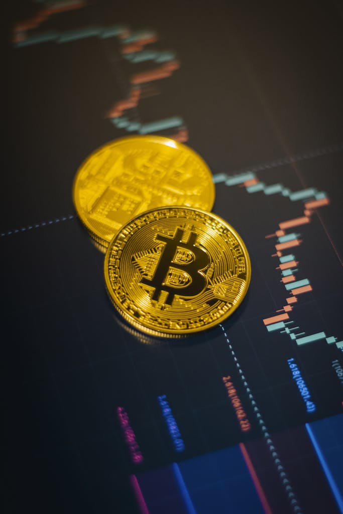Golden Bitcoin coins on a fluctuating stock market chart background.