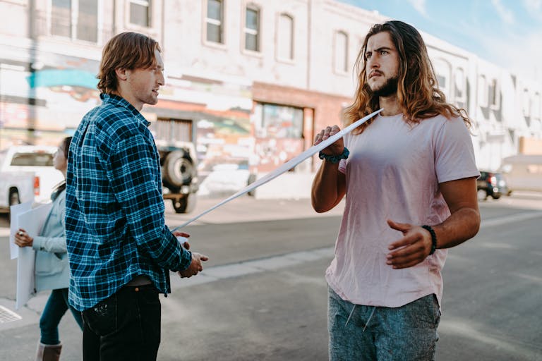 Two TimesNowNews: Shaping Modern Journalism in India men engaging in a discussion on a city street with colorful murals in the background.