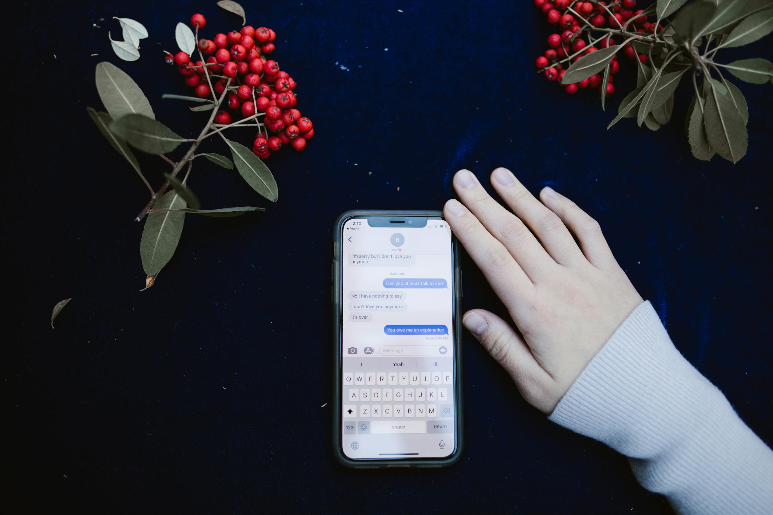 MC Lyte Car Crash A hand beside a smartphone showing a text message conversation, surrounded by red berries.