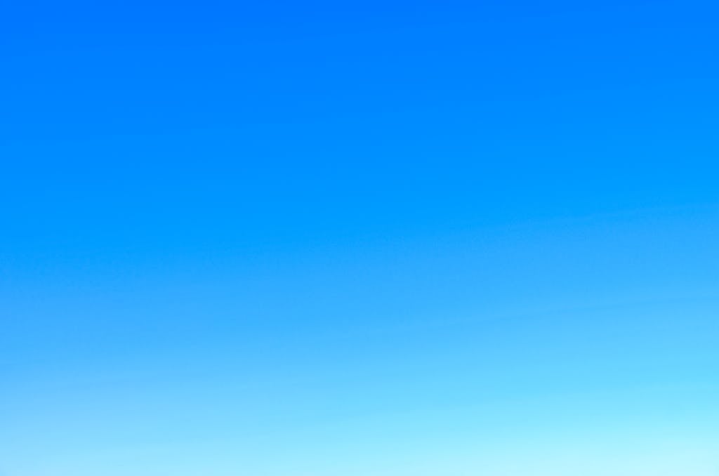 A serene view of a vibrant clear blue sky with a subtle gradient, perfect for backgrounds.