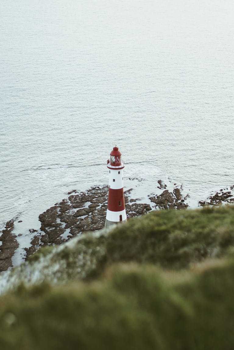 Xson208: A Comprehensive Guide to the Platform, Features, and Applications Aerial view of a red and white lighthouse on a rocky seashore surrounded by calm ocean waves.