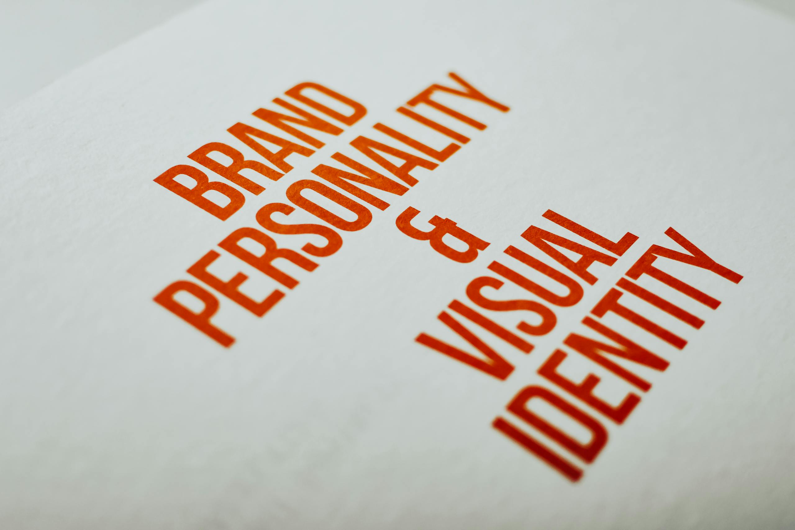 Meilaier: A Comprehensive Insight into Vision, Innovation, and Modern Brand Identity Close-up of 'Brand Personality & Visual Identity' text in red on white paper.