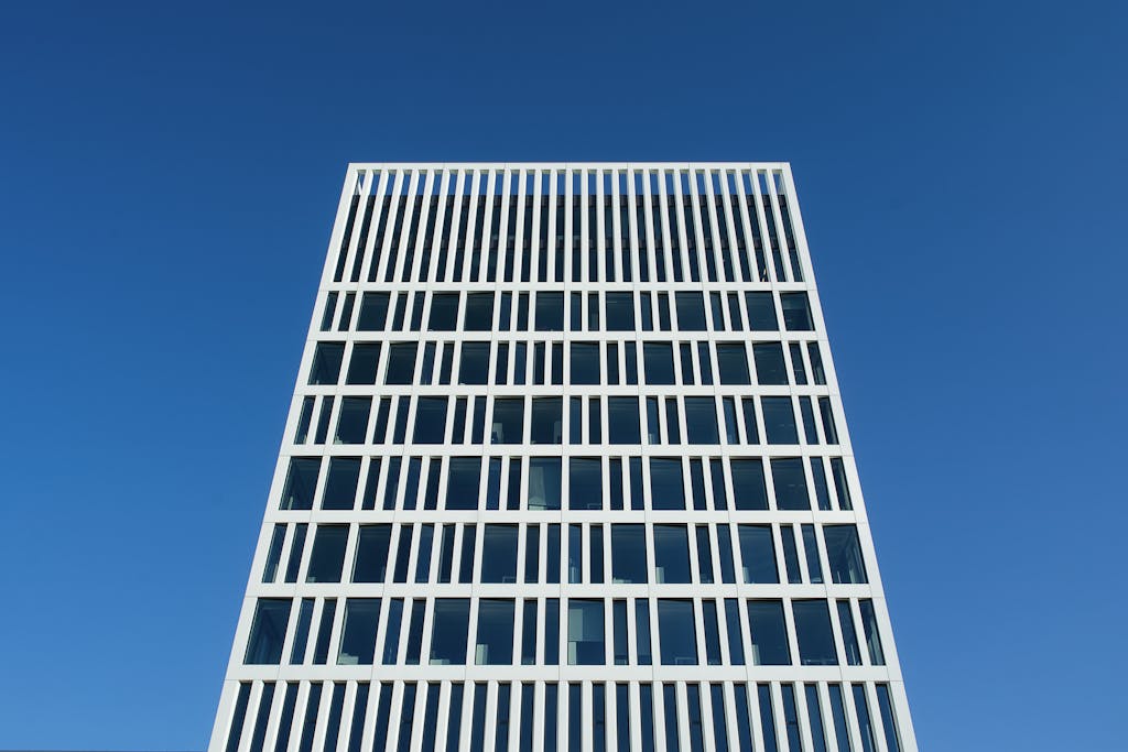 Kongotech Org Low-angle shot of a modern office building in Den Haag against a bright blue sky.