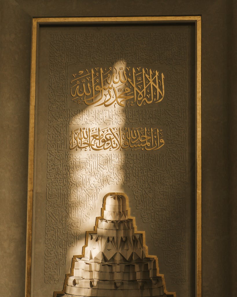 Luminous Arabic script in gold on a decorative panel, symbolizing spirituality and faith.
