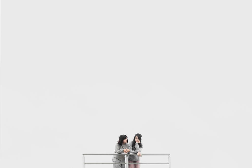 ventsMagazine Minimalist photo of two women on a balcony against a white background, expressing calmness.