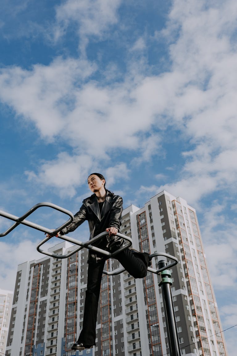 Blazertje: The Rise of a Modern Fashion StatementStylish model in black leather jacket posing on urban framework against sky and buildings.
