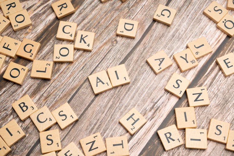 AI Wooden letter tiles scattered on a textured surface, spelling 'AI'.