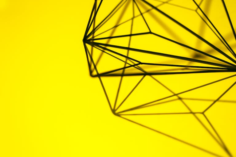 digitalconnectmag.com structure casting intricate shadows on a vibrant yellow background.