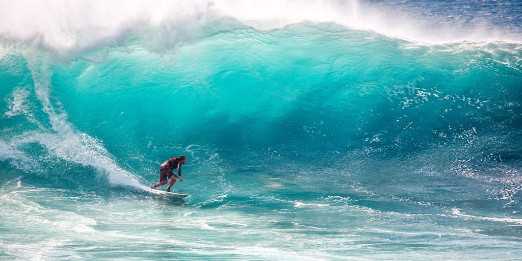 calesshop Thrilling surfing on massive turquoise waves, capturing the essence of ocean sports and adventure.