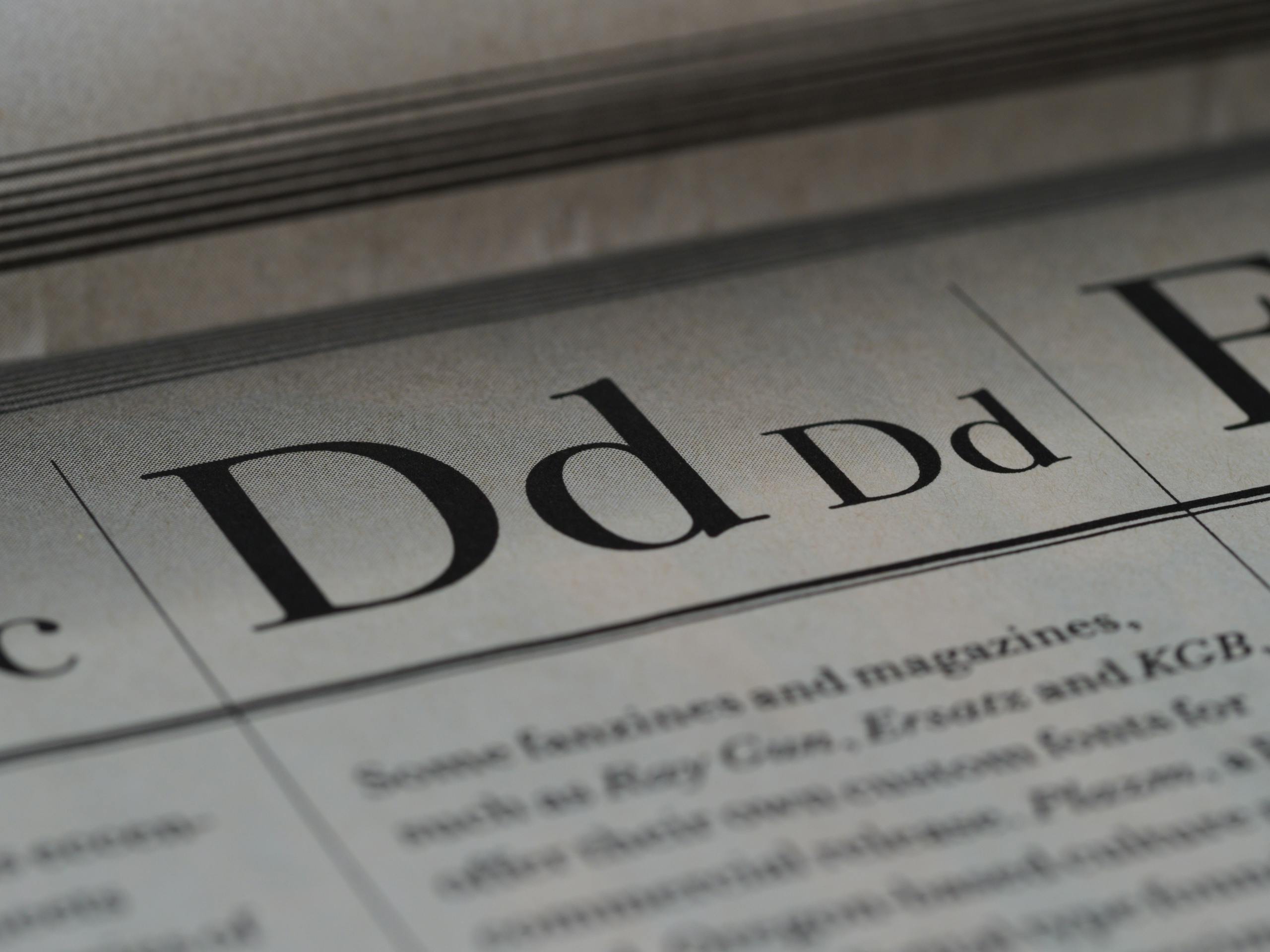 BlogBuzzNews.com Detailed close-up of a newspaper showing typography and lettering design.