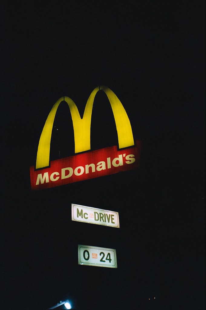 BlogBuzzNews.com Night view of an illuminated McDonald's sign in Sofia, Bulgaria, highlighting the McDrive feature.