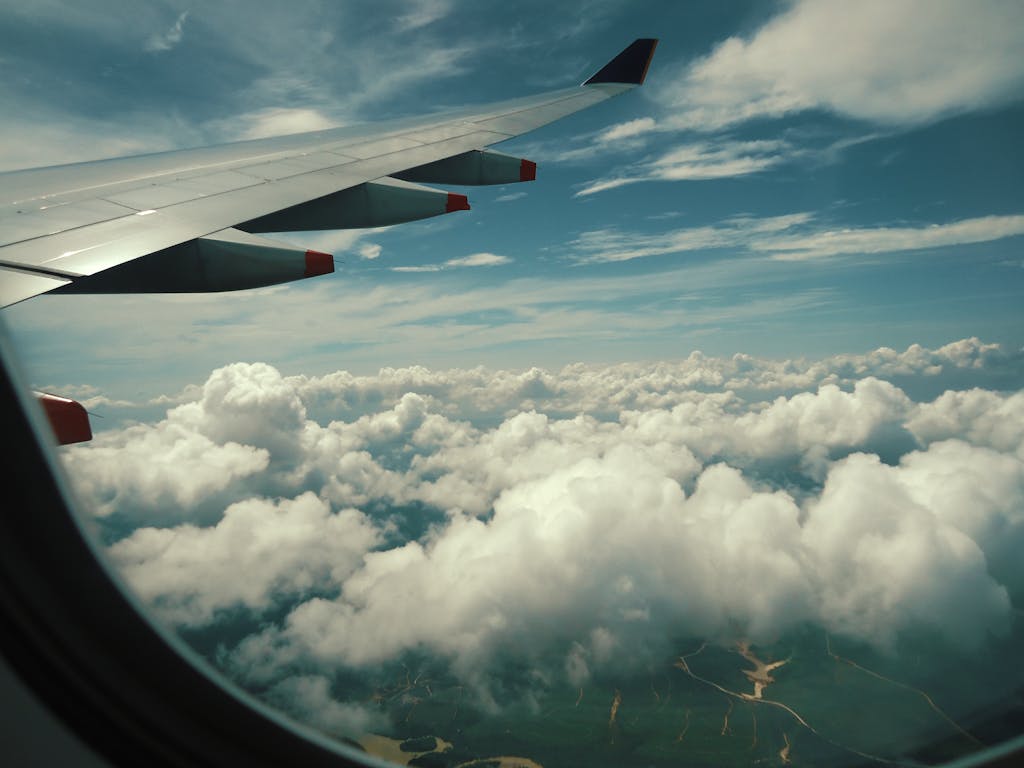 Openskynews Serene view of fluffy white clouds from an airplane window during a scenic flight.