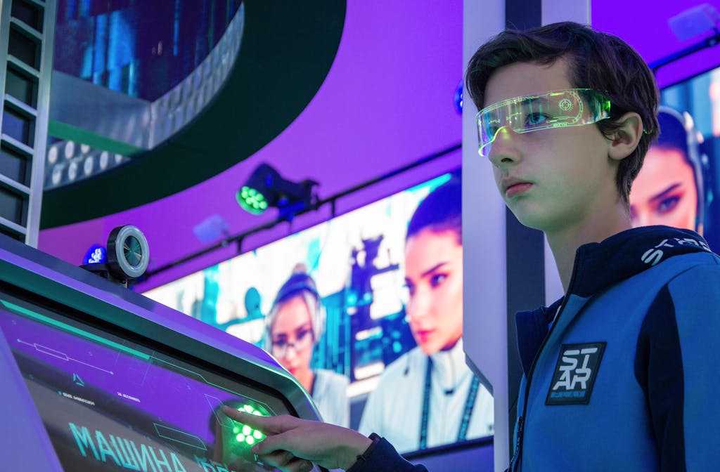Teenager interacts with advanced touchscreen in a vibrant technology exhibition.
