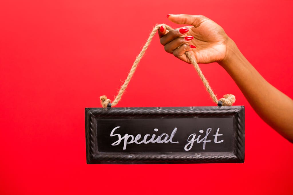 WhatUTalkingBoutWillis Gift Guide A hand holding a chalkboard sign with 'Special Gift' text against a red background.