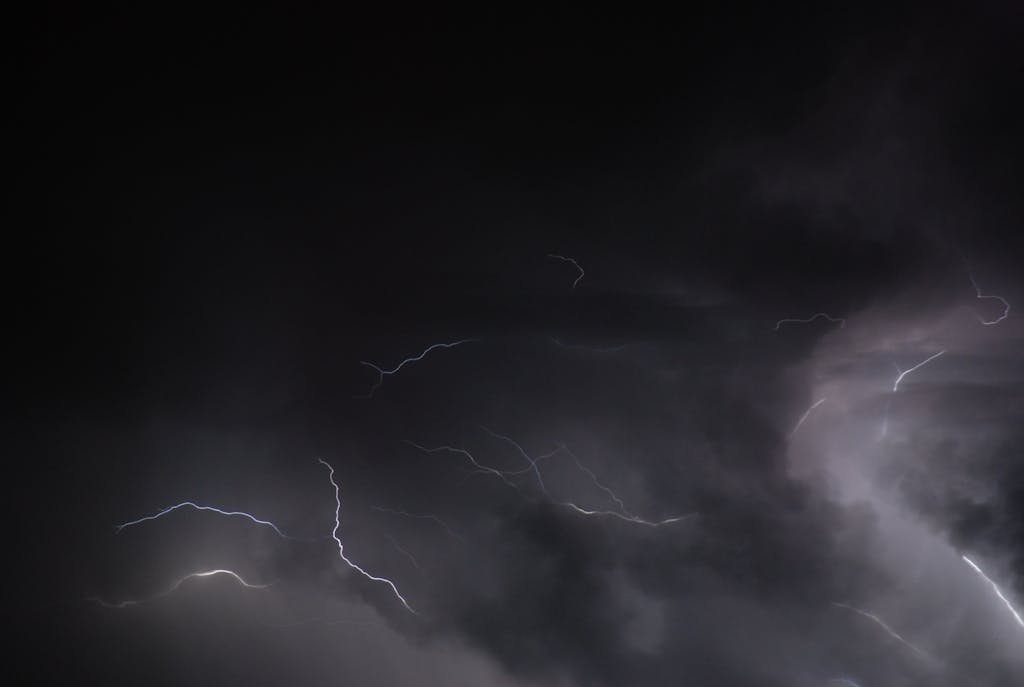 Petir108win.online Intense lightning flashes illuminate a dark sky during a powerful thunderstorm.