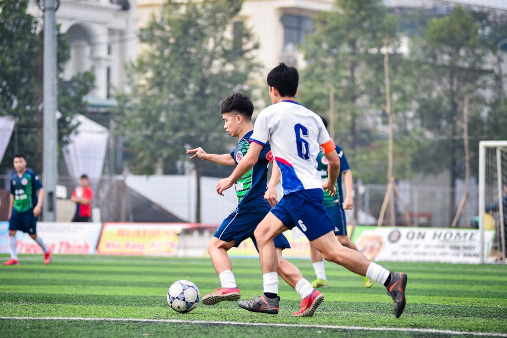 StreamEast Soccer Intense youth soccer game on an artificial turf in Hà Nội, capturing sportsmanship and action.