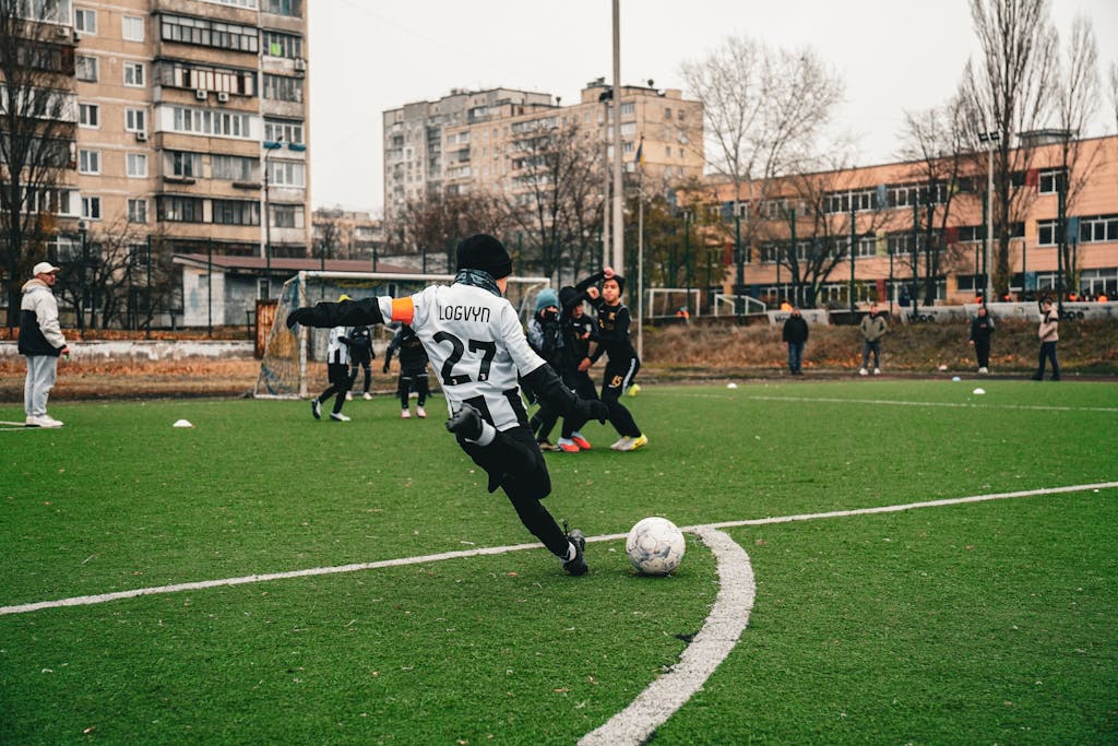 StreamEast Soccer Kids playing soccer on an urban field in Kyiv, showcasing teamwork and sportsmanship.