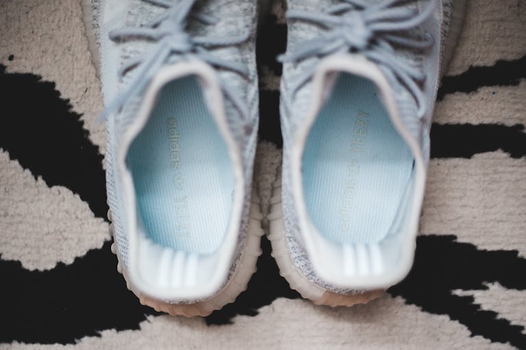 Cloud Insoles Top view new light blue cozy sneakers placed on black and white carpet at home