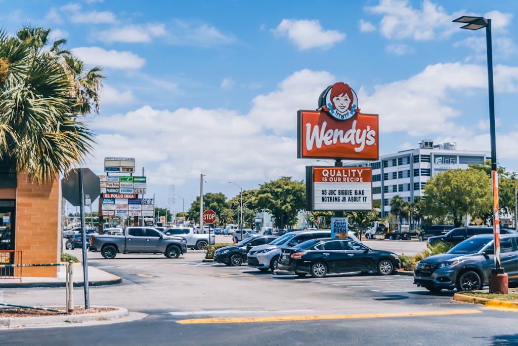 Wendy Etris Wendy's parking area crowded with cars under a clear blue sky in Orlando.