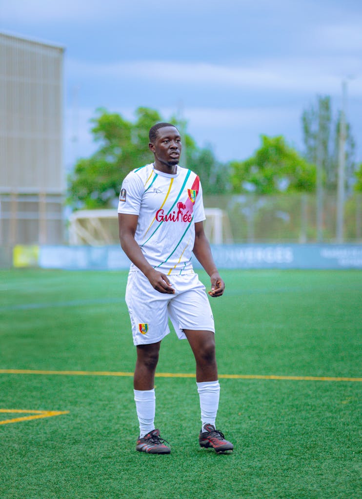 Berniece Julien Young male soccer player in uniform on an outdoor field under bright daylight.